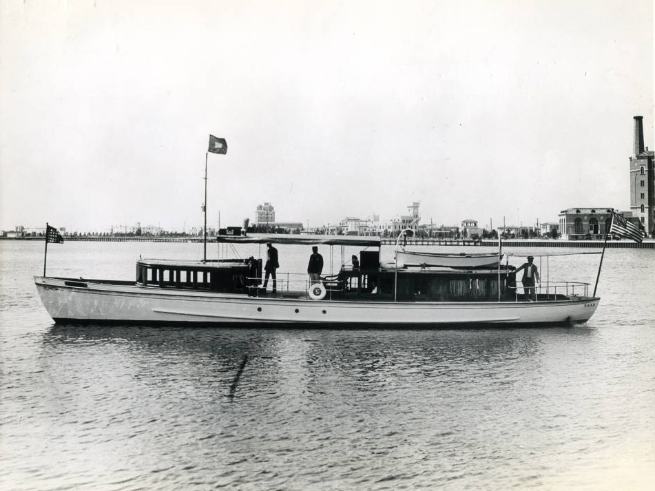 side view of a short and slender boat on a wide body of water